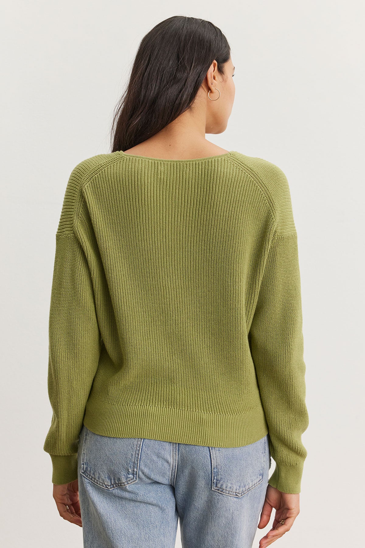 Woman viewed from behind wearing a Velvet by Graham & Spencer Tava Cardigan and faded blue jeans, standing against a plain white background.-36998741754049