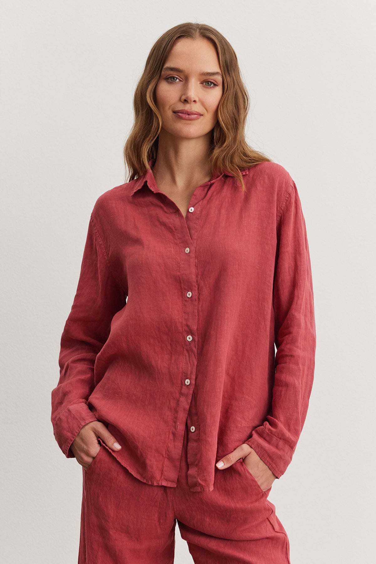 Woman in a casual red Willow Linen Button-Up shirt and matching pants, standing against a neutral background, looking directly at the camera with a slight smile. (Brand: Velvet by Graham & Spencer)-36909598277825
