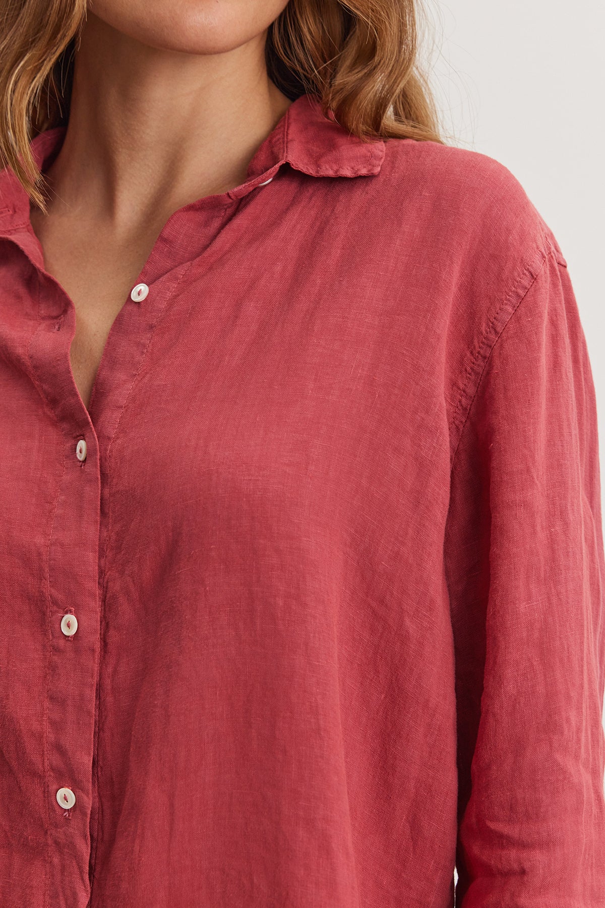 Close-up of a woman wearing a red woven linen WILLOW LINEN BUTTON-UP SHIRT by Velvet by Graham & Spencer with a focus on the collar and button details.-36909598376129