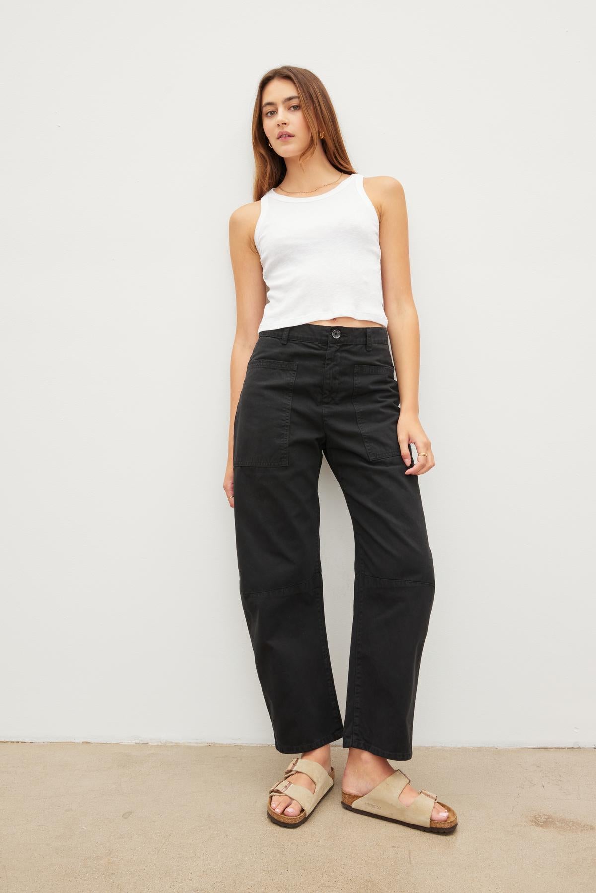 A woman wearing Velvet by Graham & Spencer's BRYLIE SANDED TWILL UTILITY PANT and a white tank top.-36040341487809