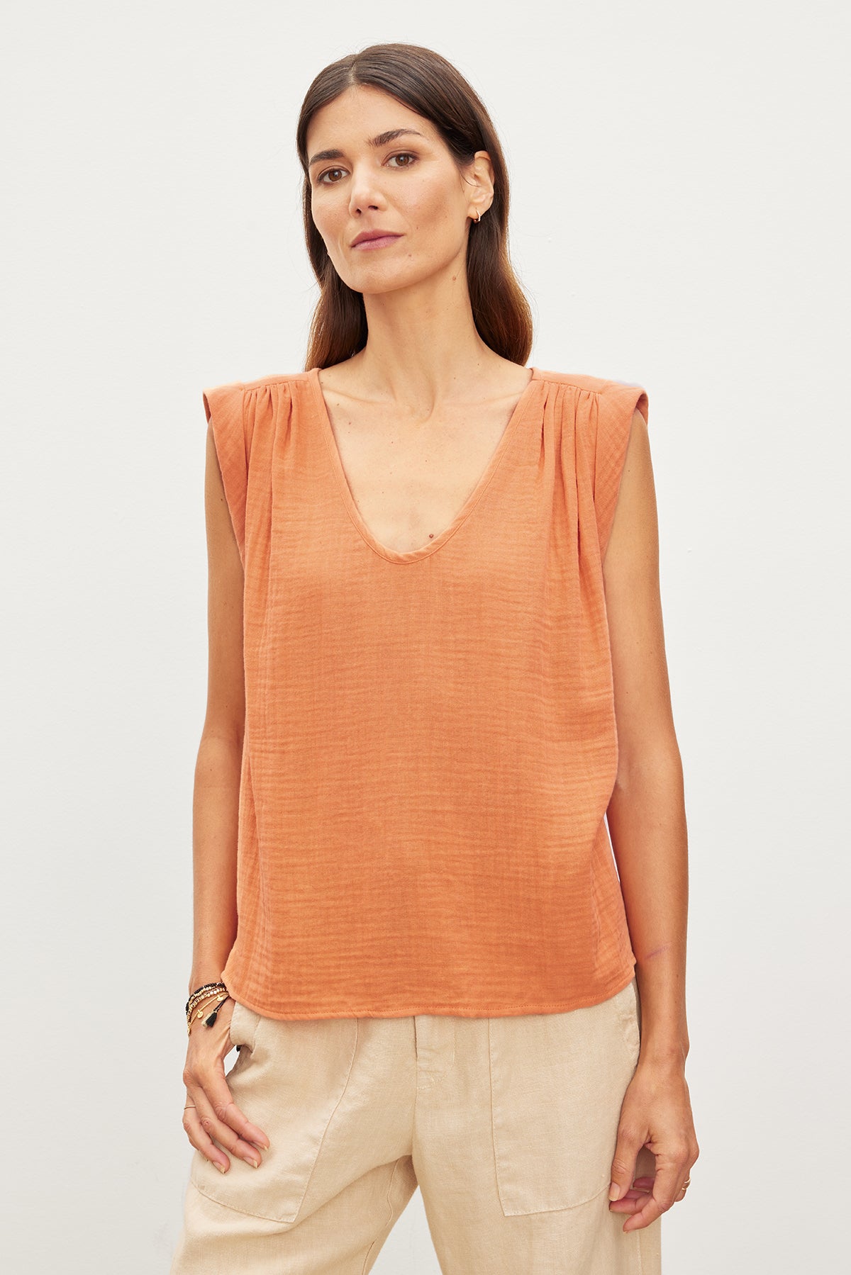   A woman wearing a JAYLA COTTON GAUZE TANK TOP in an orange color by Velvet by Graham & Spencer. 