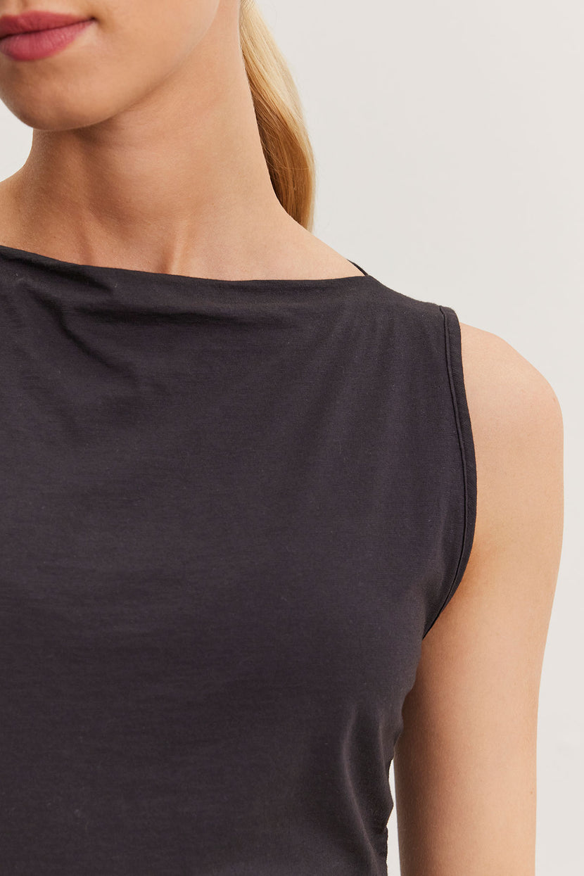 Close-up of a woman wearing a black one-shoulder EMILIA tank top by Velvet by Graham & Spencer, focusing on the neckline and shoulder detail.