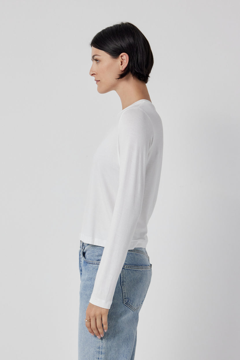 The back view of a woman wearing Velvet by Jenny Graham stretch jeans and a white long sleeved Pacifica Tee.