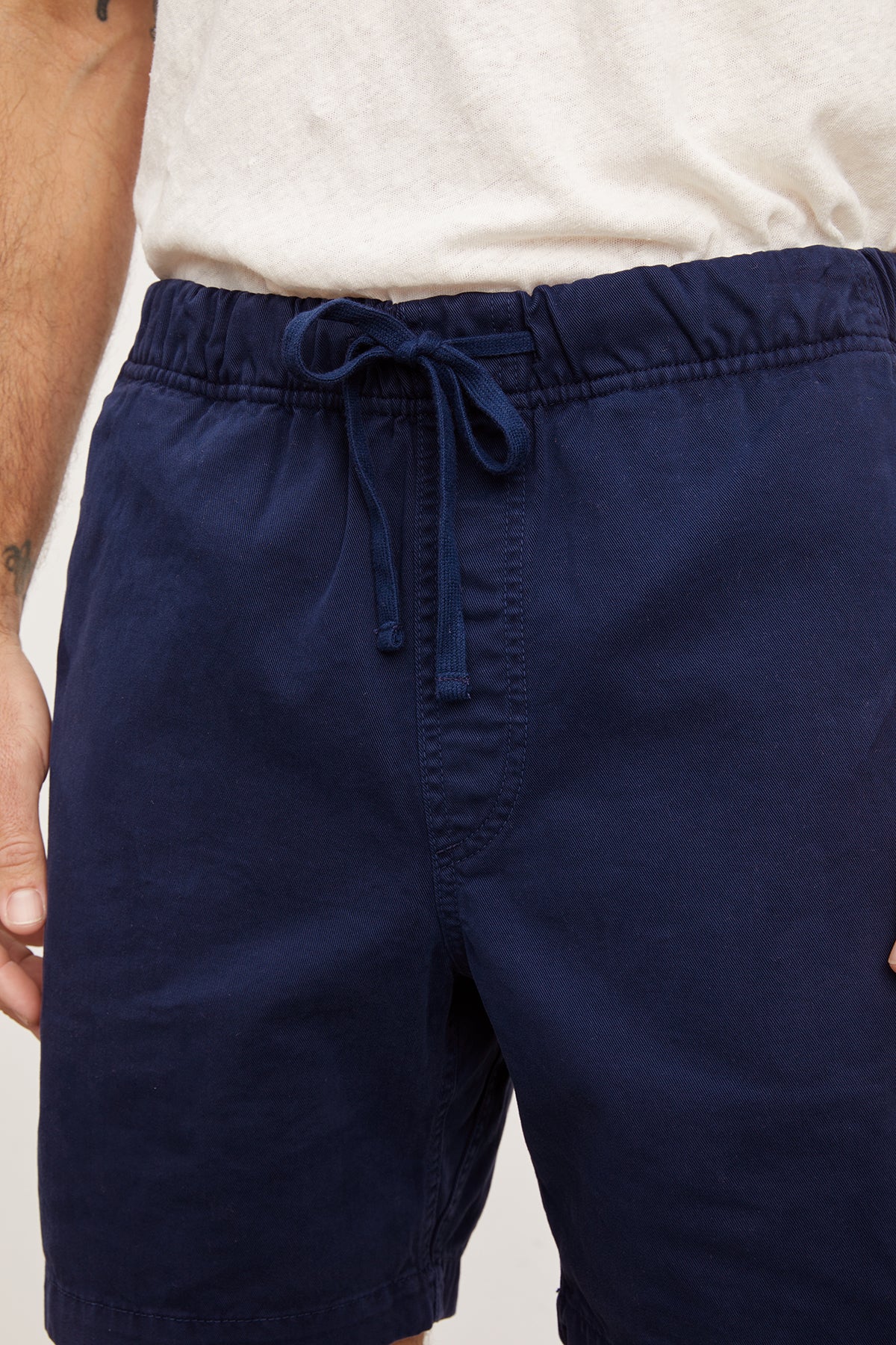 Close-up of a man wearing Velvet by Graham & Spencer FIELDER SHORTS, focusing on the waist area with a partial view of a hairy arm.-36909292421313