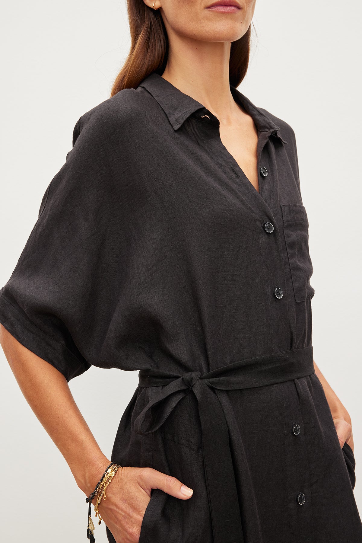 Woman in a Sandra Linen Button-Up Dress by Velvet by Graham & Spencer, with a detachable belt, cropped to show only her torso and hands.-35967717572801