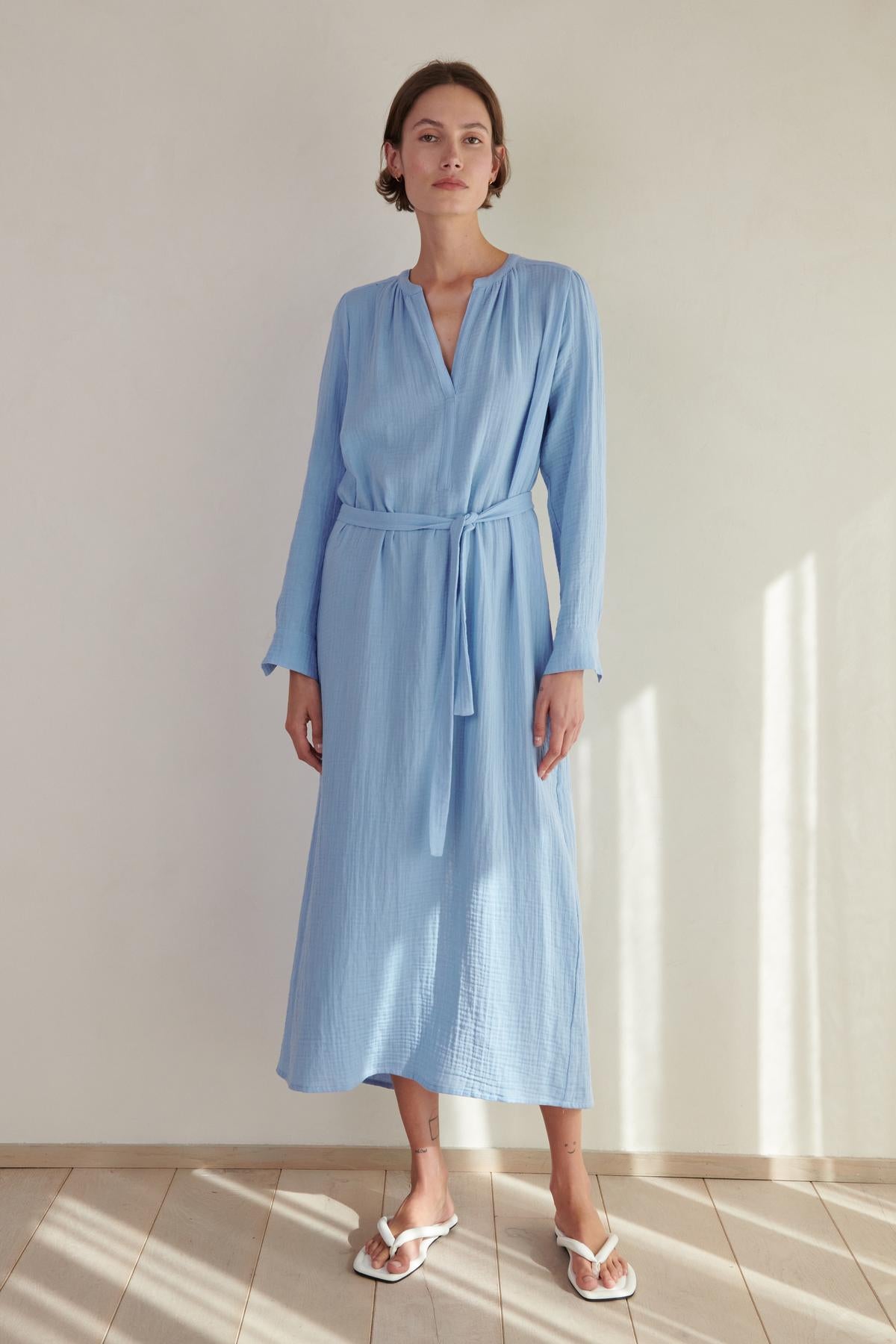 A woman wearing a blue DOHENY DRESS by Velvet by Jenny Graham and sandals.-26293207531713