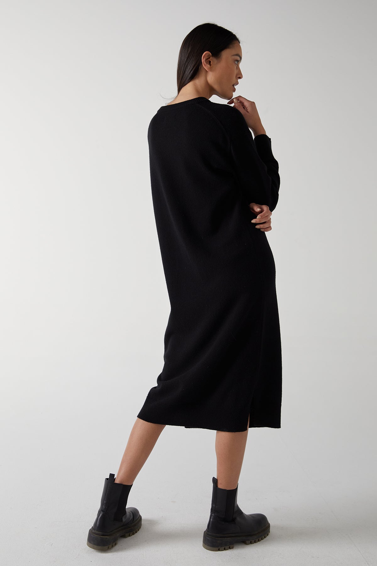 A woman showcasing the side hem slits of her LAUREL DRESS by Velvet by Jenny Graham, creating a minimal silhouette.-25315829547201