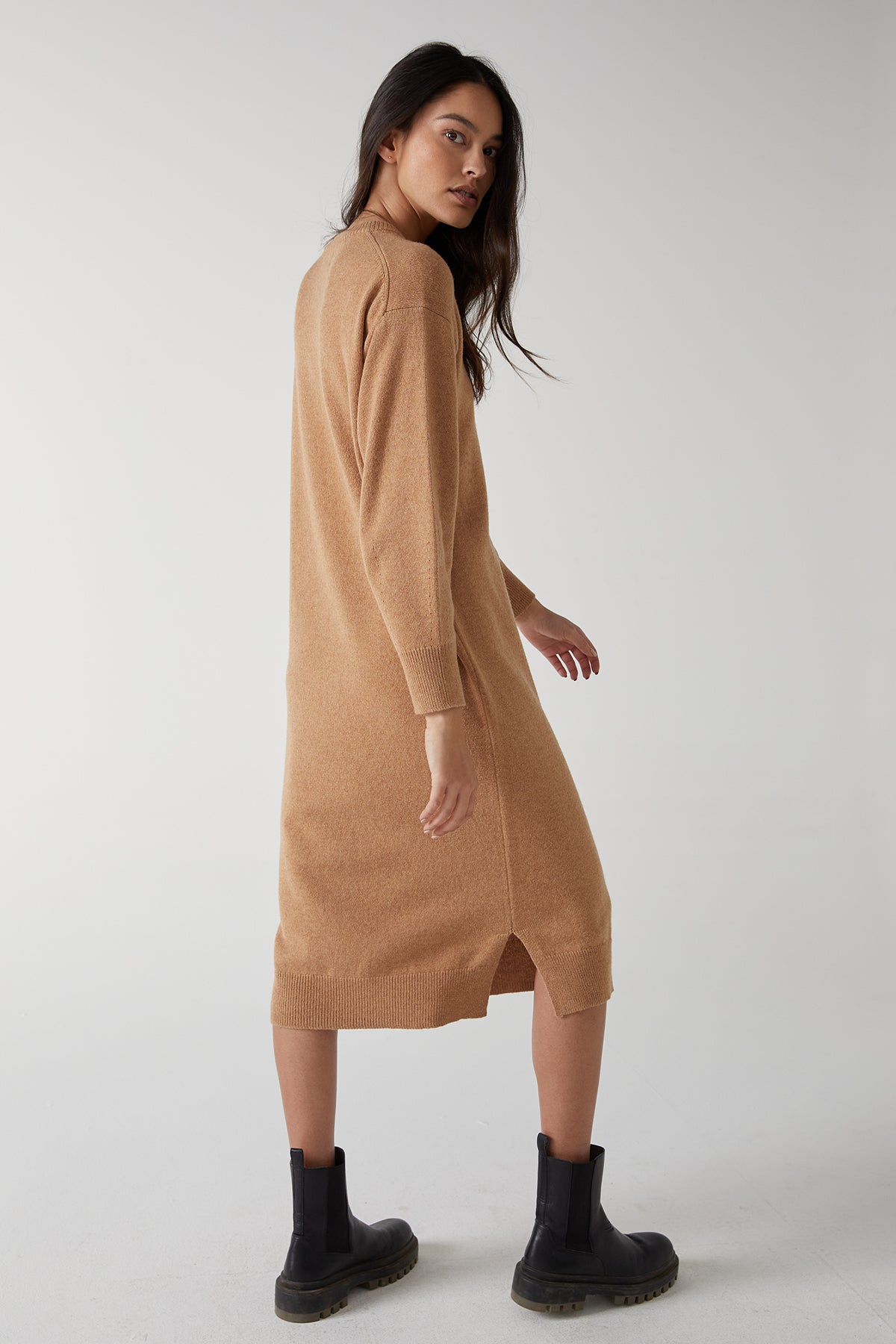 The model is wearing a LAUREL DRESS by Velvet by Jenny Graham, a modern sweater dress with side hem slits, in a camel hue.-25315843834049