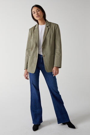 The model is wearing a ECHO BLAZER by Velvet by Jenny Graham and flared jeans.